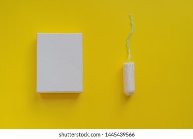 Menstrual Period Concept. Woman Hygiene Protection. Cotton Tampon  In A White Boxon On Yellow Background. Copy Space And Mockup