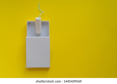 Menstrual Period Concept. Woman Hygiene Protection. Cotton Tampon  In A White Boxon On Yellow Background. Copy Space And Mockup