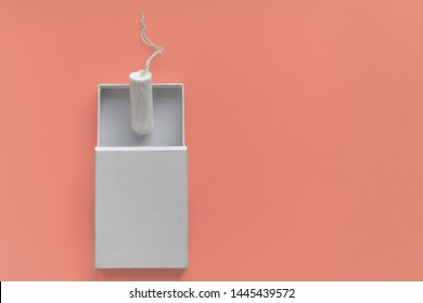 Menstrual Period Concept. Woman Hygiene Protection. Cotton Tampon  In A White Boxon On Coral Background. Copy Space And Mockup