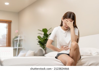 Menstruation, period cycle day of monthly, hurt asian young woman, female hand in stomachache, suffer from PMS premenstrual, belly or abdomen pain on bed at home. Health problem Inflammation in body