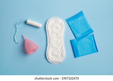 Menstruation Products, Woman Intimate Hygiene, Sanitary Pads, Reusable Silicon Cup And Tampon On Blue