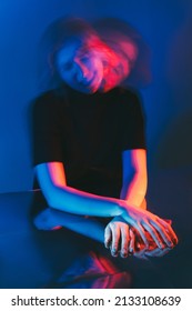 Mental Disorder. Anxiety Attack. Schizophrenia Psychiatry. Double Exposure Silhouette Of Frustrated Mad Woman Shaking Head In Pink Blue Neon Color Light Isolated On Dark Out Of Focus.