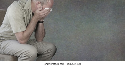 Mental Health Awareness Campaign For Men Background Banner - Crying Man With Hands Holding White Tissue Against Eyes On A Rustic Neutral Grey Background With Copy Space For Message
