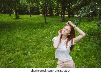 Mental Health Awareness Month, Behavioral Health Care. Post COVID-19 Pandemic Mental Health Challenges. Red-haired Young Woman On Green Nature Trees And Flowers Background