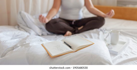 Mental health care, positive thinking and wellness concept. Woman lying in bed, practicing stress relief challenge with journal about feeling, glass of water and gratitude list, focus on word mental