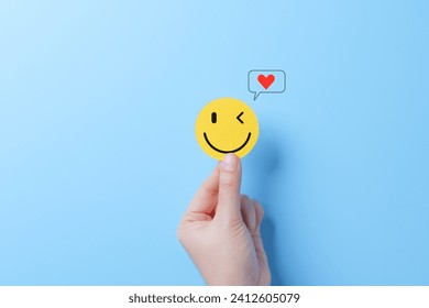 Mental Health Day concept. Hand holding a smiley face icon that depicts happy and giving a heart of love in the message box. positive thinking, Take care of your mental health, Customer satisfaction, - Powered by Shutterstock