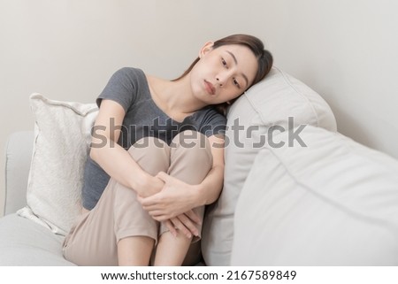 Mental health, depressed sad asian young woman, girl sitting on sofa, couch, expression to face difficulty, failure and exhausted. Thoughtful worried suffering depression feeling lonely, alone at home