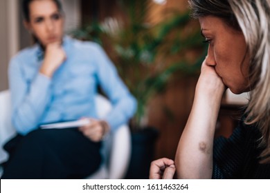 Mental Health Disorder Addressed Through Psychotherapy, Troubled woman with bruises, in session with psychotherapist  - Shutterstock ID 1611463264