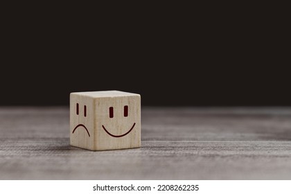 Mental health and emotional state concept, Smile face in bright side and sad face in dark side on wooden block cube for positive mindset selection. - Shutterstock ID 2208262235