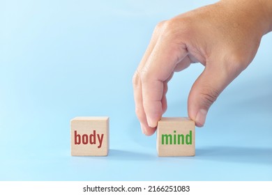 Mental Health Over Physical Health Concept. Human Hand Choose Healthy Mind Versus Body Word On Wooden Blocks.