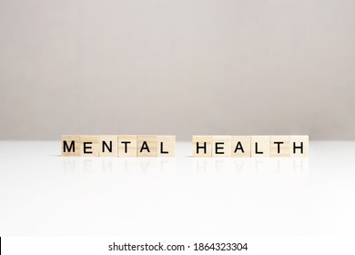 Mental Health Phrase Made Of Wooden Letters On White Table Side View. Raising Awareness Of Mental Health Issues. Psychosocial Support Concept. Emotional Health, Well-being, Common Problems