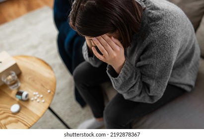 mental health, psychological problem and depression concept - close up of stressed woman with sedative medicine or painkiller on table having headache at home - Shutterstock ID 2192878367