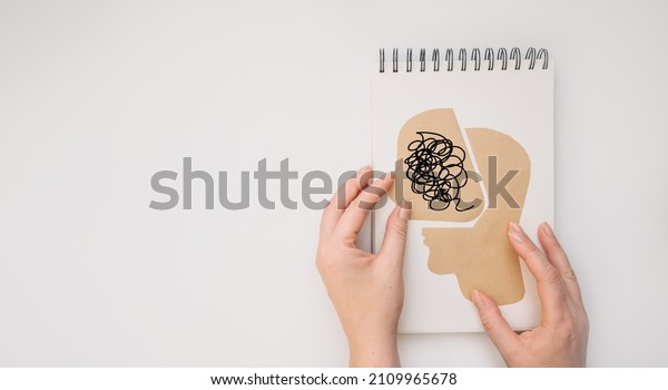 MENTAL HEALTH Mental Psychological Stress\
Management and Psychological trauma Health. Hand holding paper cut\
head on white background