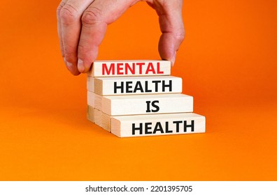 Mental Health Psychological Symbol. Concept Words Mental Health Is Health On Wooden Blocks On A Beautiful Orange Table Orange Background. Psychologist Hand. Psychological Mental Health Concept.