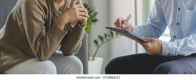 mental health treatment concept. Stressed asian patient talking with personal psychologist in therapist session have a burnout in work at clinic in office room. - Shutterstock ID 2153864211