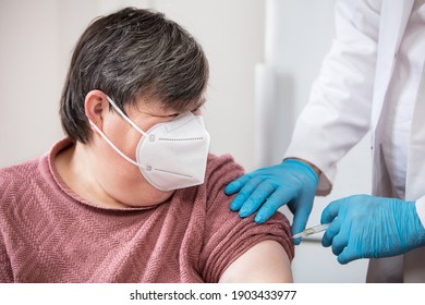 mentally disabled or handicapped woman is getting a vaccination from a male doctor or nurse