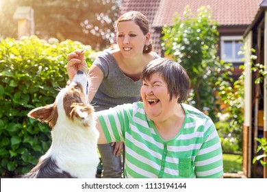 mentally disabled woman with a second woman and a companion dog, concept learning by animal assisted living - Shutterstock ID 1113194144