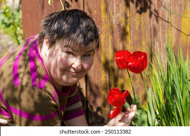 mentally disabled woman smells on a flower
