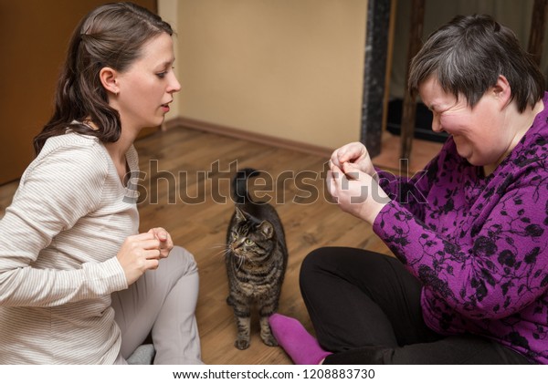 mentally disables woman and nurse with a cat, animal assisted therapy
