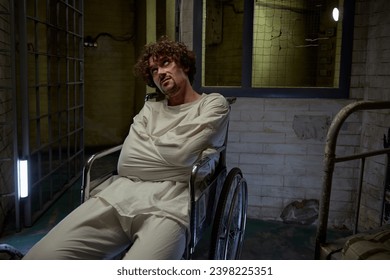 Mentally ill patient wearing straitjacket sitting in wheelchair