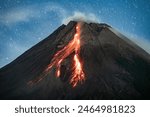 Merapi volcano eruption, hot lava flows on the slope at night.