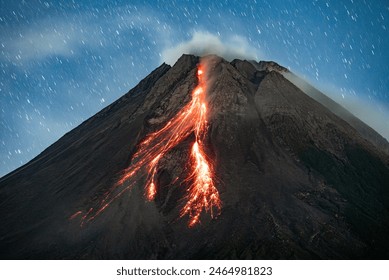 Merapi volcano eruption, hot lava flows on the slope at night.