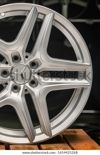 Mercedes Benz logo\
aluminum cast wheel, close-up, original silver wheel new in black\
background vertical\
concept