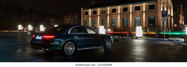 A Mercedes S-Class parked at night in front of one of the buildings of the Silesian Museum. Katowice, Poland - 02.02.2021
