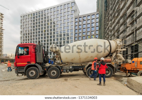 Mercedes-Benz Actros model 3 4141 B is\
heavy-duty truck by Mercedes Benz with Liebherr concrete truck\
mixer (LIEBHERR HTM 1004) on on construction site with workers of\
apartment house. Moscow\
04/2019.