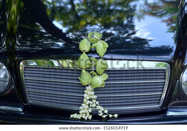Mercedes-Benz emblem logo with Garland\
of lotus flowers, in Chiang Mai -Thailand : 6 October 2019\
