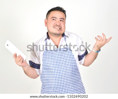 merchant Asian man in white and blue apron is feeling regret or boring when get bad news from connection internet in tablet with white background