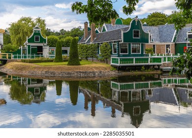 Merchant's house in Dutch Open Air Museum, Openluchtmuseum, Arnhem, Netherlands, July 29, 2022. Beautiful, old Dutch building with green authentic facade with reflection in the lake