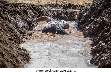 Merida, Spain - Sept 11th, 2022: FarinatoRace Merida 2022. Toughest Obstacle Course In The World. Trench Flooded With Barbed Wire