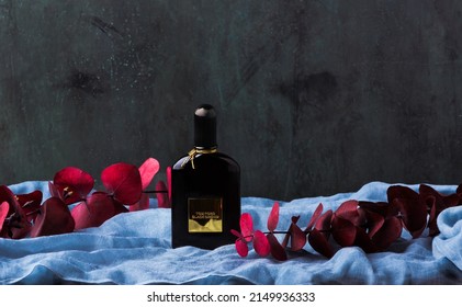 MERIDA-YUCATAN-MEXICO-MARCH-2022: 50ml bottle of the famous Tom Ford Black Orchid perfume, which is on transparent fabric in a blue tone and a semi-dark green background.