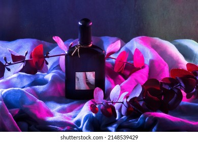 MERIDA-YUCATAN-MEXICO-MARCH-2022: 50ml bottle of Tom Ford Black Orchid perfume; which is on a thin fabric and illuminated with blue and red colors.