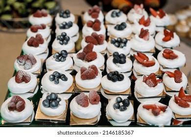 Meringue dessert Pavlova cake with fresh berries on a stone background. Pavlova berry cake with blueberries, strawberries, raspberries and on a dark background