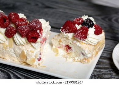 Meringue Roll With Mascarpone Cream. Garnished With Raspberries And Almond Petals. Close-up.