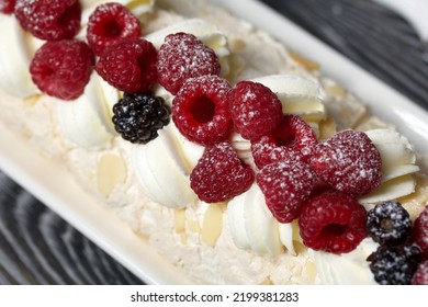 Meringue Roll With Mascarpone Cream. Garnished With Raspberries And Almond Petals. Close-up.