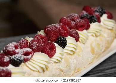 Meringue Roll With Mascarpone Cream. Garnished With Raspberries And Almond Petals. Close-up.