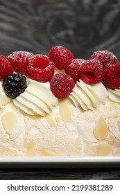 Meringue Roll With Mascarpone Cream. Garnished With Raspberries And Almond Petals. Close-up.