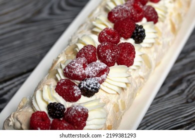 Meringue Roll With Mascarpone Cream. Garnished With Raspberries And Almond Petals. Close-up.