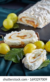 Meringue roulade with plums on a wooden board