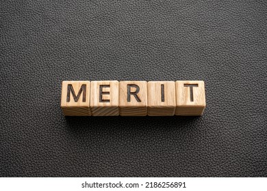 Merit - Word From Wooden Blocks With Letters, Merit Praise Reward Concept, Black Leather Background