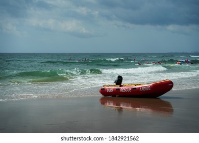 Mermaid Beach QLD Australia 10/25/2020: Surf Life Saving Water Craft Parked On The Shore Ready For A Rescue With A Group Of Little Nippers Board Training In The Background On A Stormy Day.