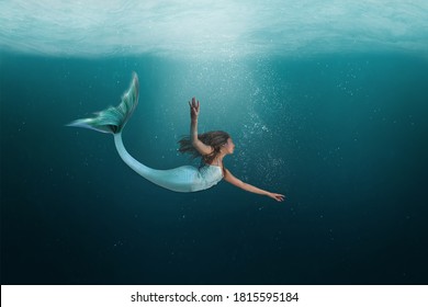 Mermaid swimming under the deep waters of the ocean. 