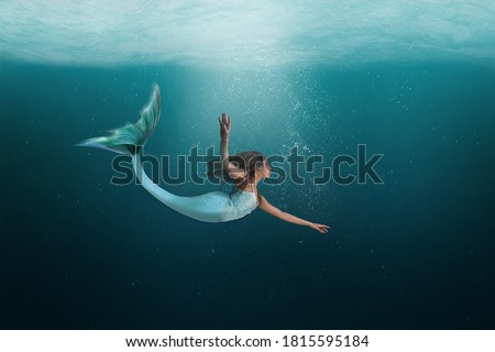 Mermaid swimming under the deep waters of the ocean. 