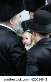 MERON ,ISRAEL- March 26, 2017: An unidentified Hasidic Rabbi gives first haircut to an unidentified Jewish Hasidic boy with blond curls as is tradition upon the grave of Rabbi Shimon on Lag Ba'omer.
 - Shutterstock ID 623014841