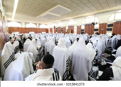 MERON, ISRAEL - May 17, 2017: Unidentified orthodox Jewish men pray while donning Tefillin and Talit (cloth) during morning prayers in Meron, Israel