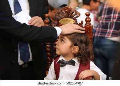 MERON,ISRAEL- October 19, 2016: Jewish Family Celebrating First Haircut To Their Jewish Boy With Blacks Curls As Is Tradition Upon The Grave Of Rabbi Shimon On Lag Ba'omer.