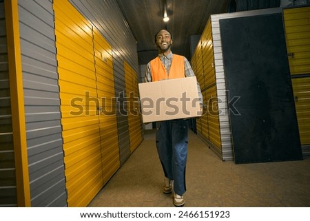 Merry cargo handler working in modern warehouse